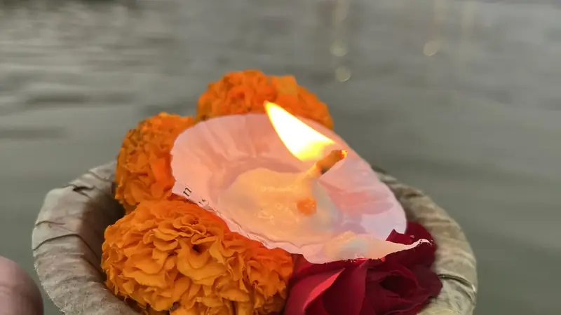 Ofrenda de diya con calendulas y petalos de rosa sobre el Ganges, en Varanasi