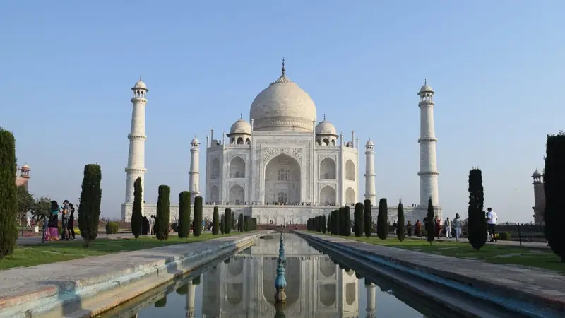 El Taj Mahal reflejado en su estanque al amanecer, en Agra, India