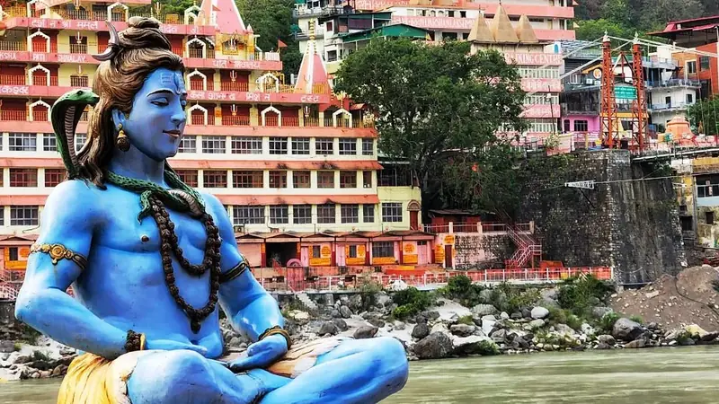 Practicante de yoga al amanecer en un ghat a orillas del río Ganges en Rishikesh, con las estribaciones del Himalaya al fondo