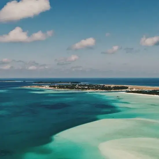 Vista aérea de un atolón de las Maldivas con laguna turquesa y banco de arena