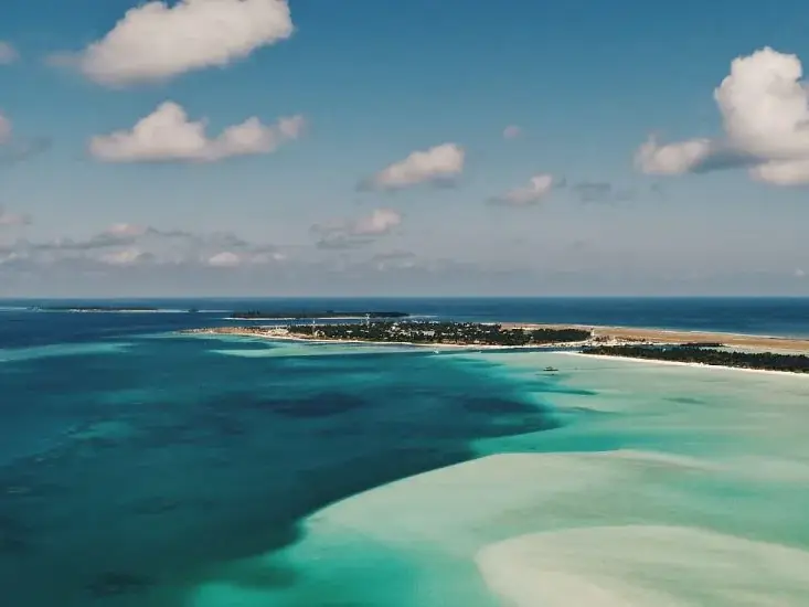 Vista aérea de un atolón de las Maldivas con laguna turquesa y banco de arena