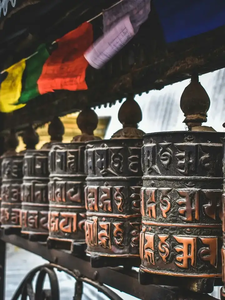 Ruedas de oración y banderas tibetanas en un templo de Katmandú, Nepal