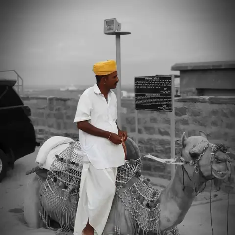 Hombre con turbante junto a un camello, retrato en blanco y negro en Jodhpur, Rajastán