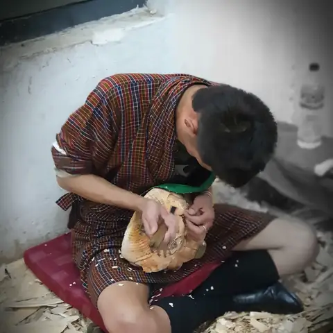 Artesano butanés tallando madera a mano en su taller