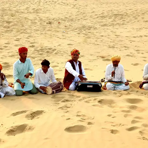 Músicos tradicionales de Rajastán tocando sentados sobre las dunas del desierto