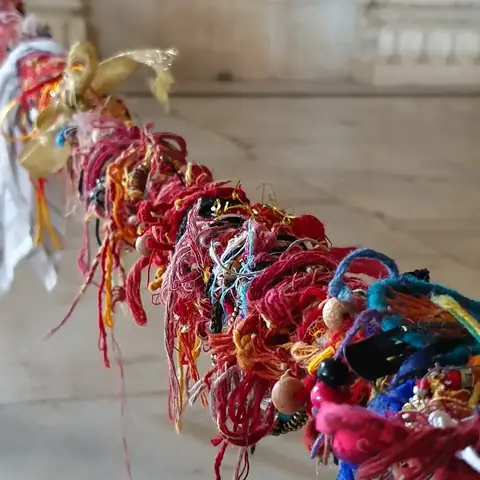 Detalle de hilos de colores (mauli) atados como ofrenda en un templo indio