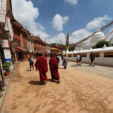 Monjes budistas caminando junto a la gran estupa de Boudhanath en Katmandú, Nepal
