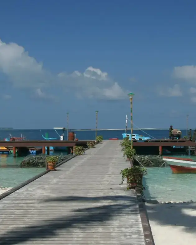 Embarcadero y dhonis de madera en una isla habitada de las Maldivas